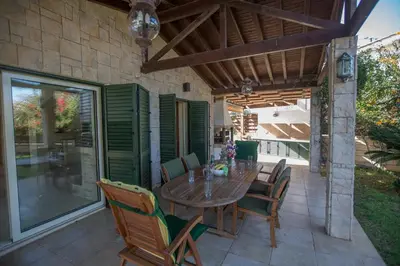 a patio with a wooden table and chairs at Protaras Holiday Villa Jo78 in Paralimni