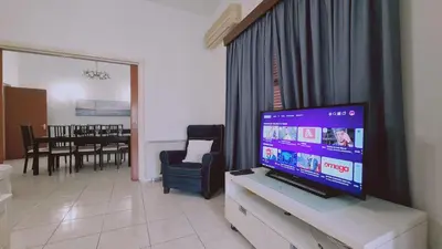 a living room with a television and a dining room at STAY Mythos Down Town House in Nicosia