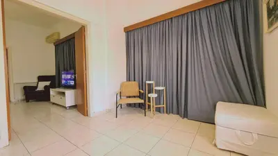 a living room with a couch and chairs and a television at STAY Mythos Down Town House in Nicosia