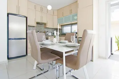 a dining room with a white table and chairs at Villa Solebianco Protaras in Protaras