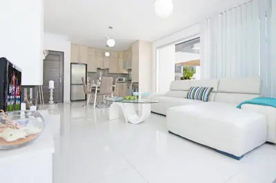 a white living room with a white couch and tables at Villa Solebianco Protaras in Protaras