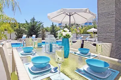 a dining table with blue bowls and plates on it at Villa Solebianco Protaras in Protaras