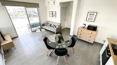 a living room with a glass table and chairs at Vacation mode Apartment in Ayia Napa