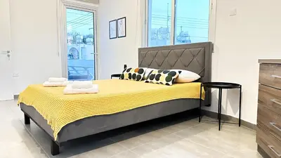 a bedroom with a bed with yellow sheets and pillows at Vacation mode Apartment in Ayia Napa