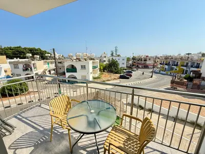 a balcony with a table and chairs and a view of a city at Vacation mode Apartment in Ayia Napa