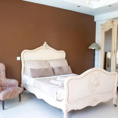 a bedroom with a white bed and a chair at Villa Artemis in Larnaka