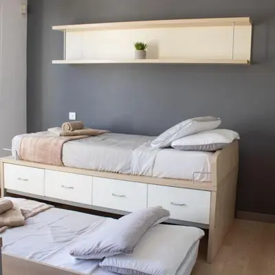 a bedroom with two beds and a shelf with pillows at Villa Artemis in Larnaka