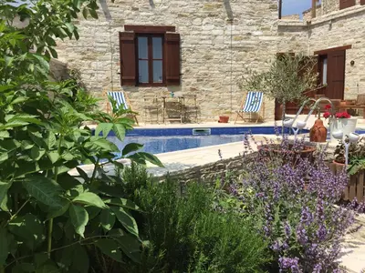 a garden with two chairs and a swimming pool at Palatakia - Adults Only in Kato Drys