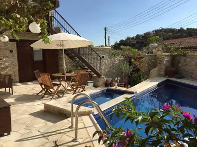 a house with a swimming pool with a table and an umbrella at Palatakia - Adults Only in Kato Drys