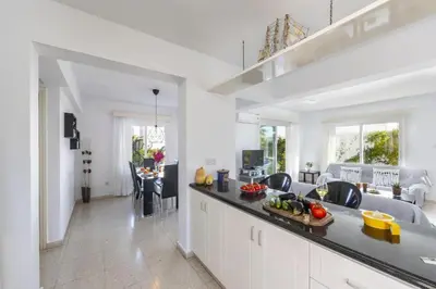a kitchen and living room with white walls and a counter top at Protaras Fig Tree Bay Sea View Villa , Jacuzzi Available April to October in Protaras