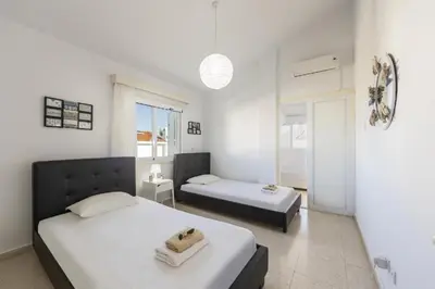a bedroom with two beds and a window at Protaras Fig Tree Bay Sea View Villa , Jacuzzi Available April to October in Protaras