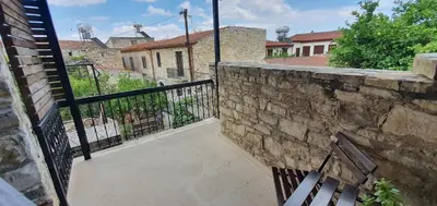 a balcony with a stone wall and a bench at Bougainvillea House Lefkara in Pano Lefkara