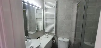 a bathroom with a sink and a toilet and a mirror at Bougainvillea House Lefkara in Pano Lefkara