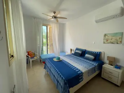 a bedroom with a blue bed with a ceiling fan at Zoe's villa by Turtle Bay in Protaras