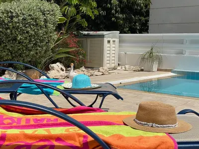 two hats sitting on a table next to a pool at Zoe's villa by Turtle Bay in Protaras