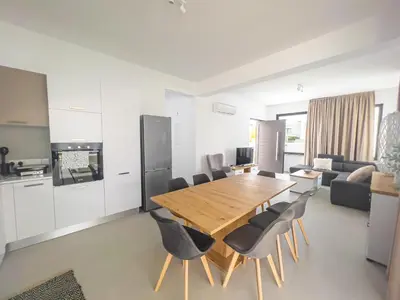 a kitchen and dining room with a wooden table and chairs at Nelia Panorama Villa in Protaras