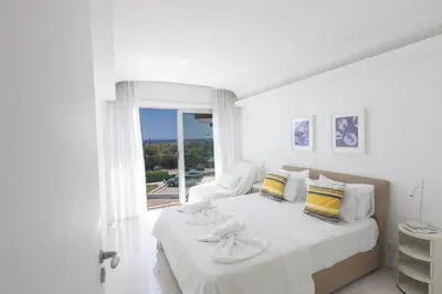 a white bedroom with a bed and a window at Protaras Thalassa Apartment Ta206 in Protaras