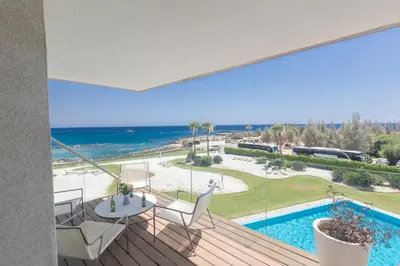 a balcony with a view of a pool and the ocean at Protaras Thalassa Apartment Ta206 in Protaras
