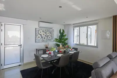 a dining room with a table and chairs and a couch at Sunrise Villa 9 in Ayia Napa