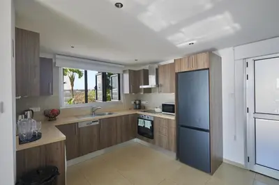 a kitchen with wooden cabinets and a blue refrigerator at Sunrise Villa 9 in Ayia Napa
