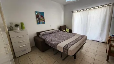 a bedroom with a bed and a dresser and a window at Ayia Napa Cyprus in Paralimni
