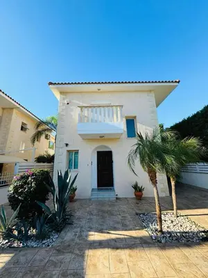 a white house with palm trees in front of it at Anna Villa in Protaras