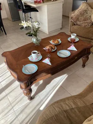 a wooden coffee table with plates of food on it at Anna Villa in Protaras