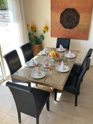 a wooden table with chairs and plates of food on it at Anna Villa in Protaras