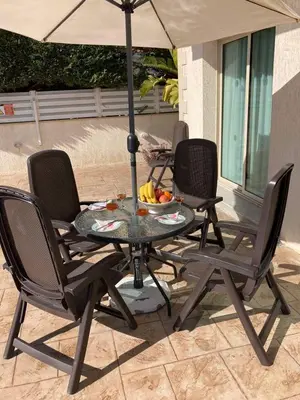 a table and chairs with an umbrella on a patio at Anna Villa in Protaras