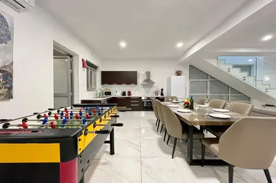 a dining room with a pool table and a kitchen at Villa Selena in Protaras