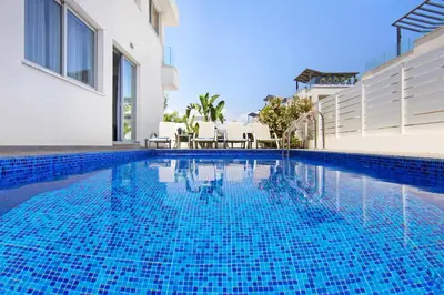 a swimming pool in a villa with blue water at Villa Selena in Protaras