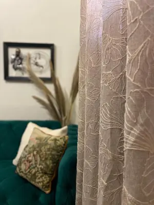 a curtain with a pillow on a green couch at Oikos Selinolithos in Alaminos