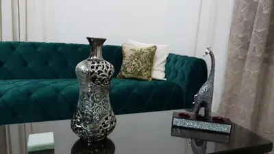 a vase on a table in front of a couch at Oikos Selinolithos in Alaminos