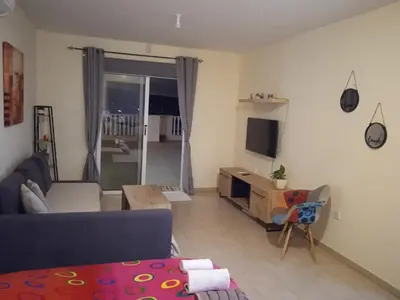 a living room with a couch and a tv at Xylophagou Rest and Relax 2 Ayia Napa Larnaca 1 bedroom apartment in Xylophaghou