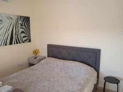 a bedroom with a bed and a picture of a zebra at Xylophagou Rest and Relax 2 Ayia Napa Larnaca 1 bedroom apartment in Xylophaghou