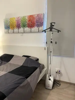 a bedroom with a bed and a painting on the wall at Unforgettable Experience in a Modern Apartment! in Larnaka