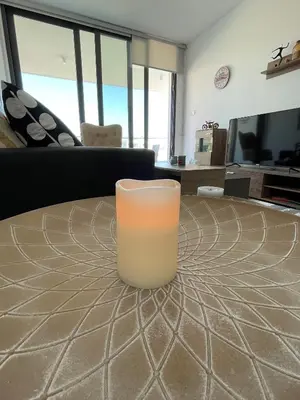 a glass sitting on a table in a living room at Unforgettable Experience in a Modern Apartment! in Larnaka