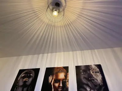 four pictures on a wall with a ceiling fan at Unforgettable Experience in a Modern Apartment! in Larnaka