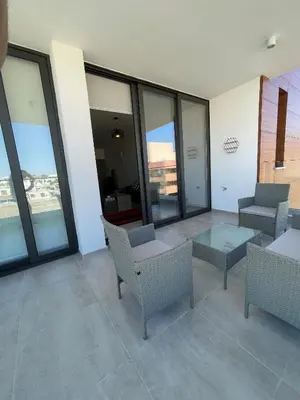 a room with chairs and a table and windows at Unforgettable Experience in a Modern Apartment! in Larnaka