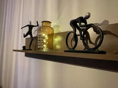 two statues of people on a shelf with a bottle at Unforgettable Experience in a Modern Apartment! in Larnaka