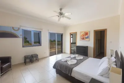 a bedroom with a bed and a balcony at Protaras Holiday Villa Pa7 Private 7 Bedroom villa in Protaras