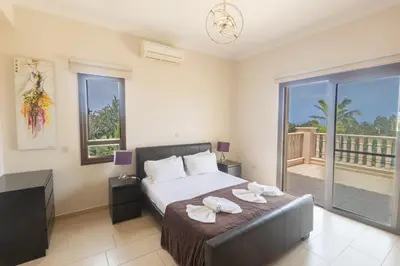 a bedroom with a bed and a balcony at Protaras Holiday Villa Pa7 Private 7 Bedroom villa in Protaras