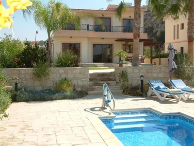 a villa with a swimming pool and a house at Three bedroom villa with private pool and landscaped garden close to the beach in Pissouri