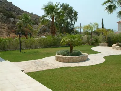a garden with a palm tree in the middle at Three bedroom villa with private pool and landscaped garden close to the beach in Pissouri