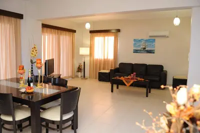 a living room with a table and a couch at Three bedroom villa with private pool and landscaped garden close to the beach in Pissouri