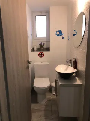 a bathroom with a toilet and a sink and a window at Great Views Apartment II in Limassol