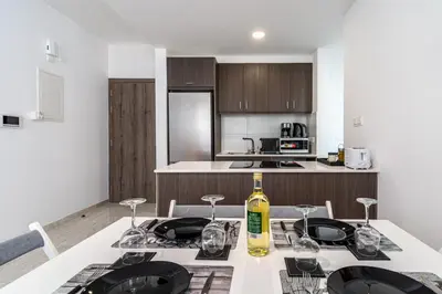 a kitchen with a table with a bottle of wine on it at Lana 1-Bedroom Apt in Larnaca in Larnaka