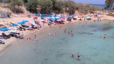a crowd of people on a beach with umbrellas at Soula Beach House in Protaras