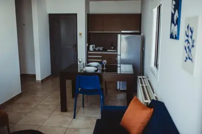 a kitchen with a table and a refrigerator at Ovis Hotel Apartments in Ayia Napa