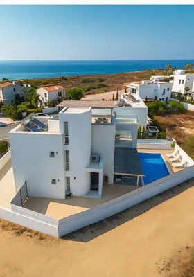 a white house with a view of the ocean at Geo Panoramic Villa Konnos - Pool, Game Room, Gym in Protaras
